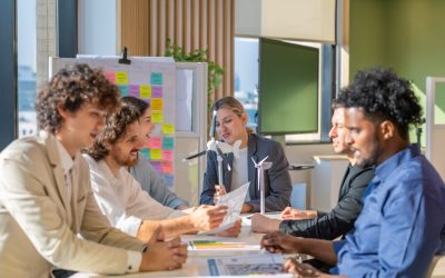 A diverse startup team develop, collaborates on a powerful, lightweight, portable wind turbine prototype, aligning with potential user demand and renewable energy needs to secure investor funding.