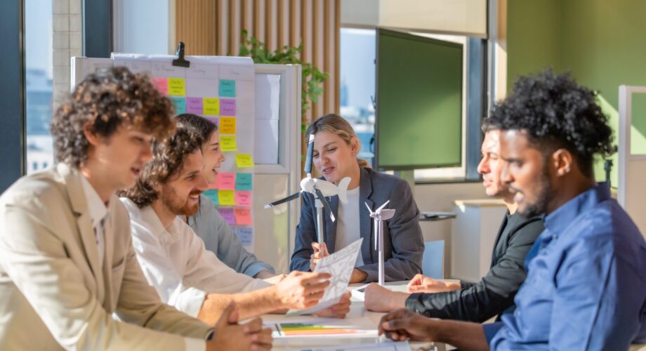 A diverse startup team develop, collaborates on a powerful, lightweight, portable wind turbine prototype, aligning with potential user demand and renewable energy needs to secure investor funding.