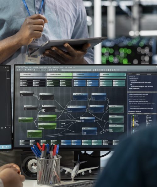 Close up of data center programmers using PC to visualize artificial intelligence neural networks. Server farm IT experts looking at monitor, working together to oversee AI systems