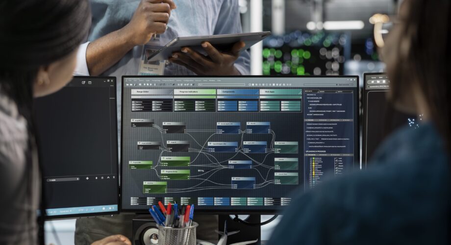 Close up of data center programmers using PC to visualize artificial intelligence neural networks. Server farm IT experts looking at monitor, working together to oversee AI systems